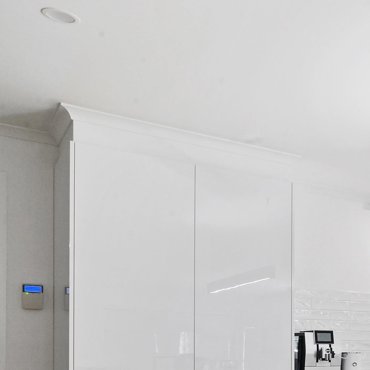 White gloss kitchen cabinetry with subway splashback